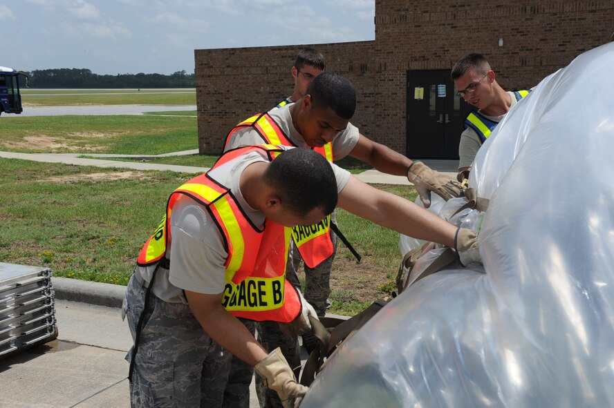 SEYMOUR JOHNSON AIR FORCE BASE, N.C. -- Airman 1st Class Julian Coleman and Senior Airman Rafael Rodriguez palletize luggage during operational readiness exercise Coronet Warrior 10-04 here July 19, 2010.  Airmen palletize the luggage to maximize aircraft space to ensure there is room for deploying personnel and their required equipment. Airman Coleman, 4th Force Support Squadron services technician, hails from Colorado Springs, Colo. Airman Rodriguez, 4th Communication Squadron client support administrator technician, hails from Manhattan, N.Y. (U.S. Air Force photo/Senior Airman Gino Reyes)