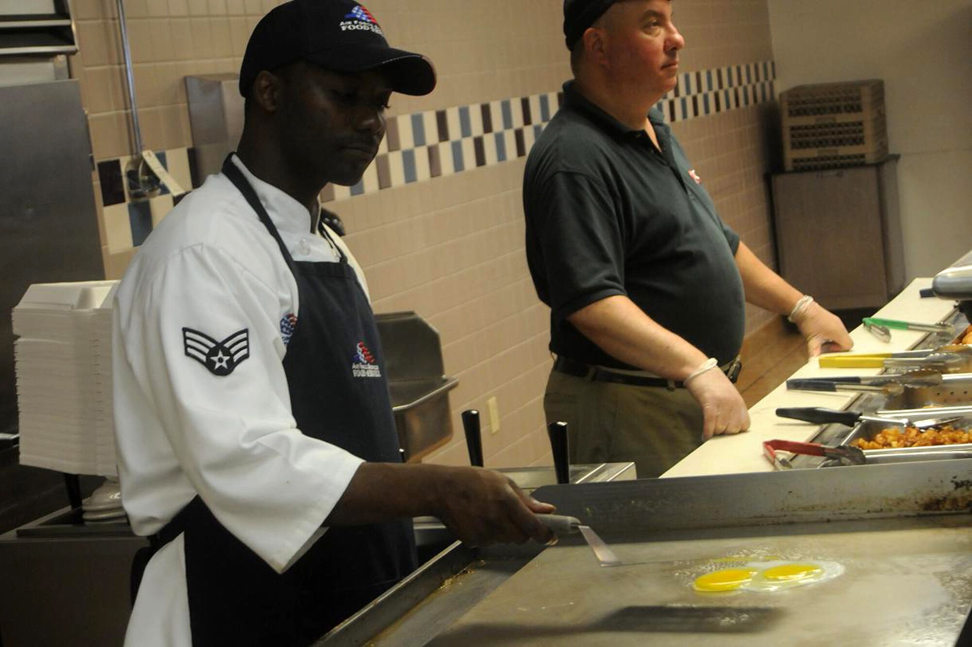 Senior Airman Shemeil Christopher, 512th Memorial Affairs Squadron, food preparation specialist, Dover Air Force Base, Del., grills an omelet in Patterson Dining Facility kitchen here June 6. Airman Christopher said he likes to cook and enjoys working in the kitchen. (U.S. Air Force photo/Senior Airman Bhawan P. Singh)