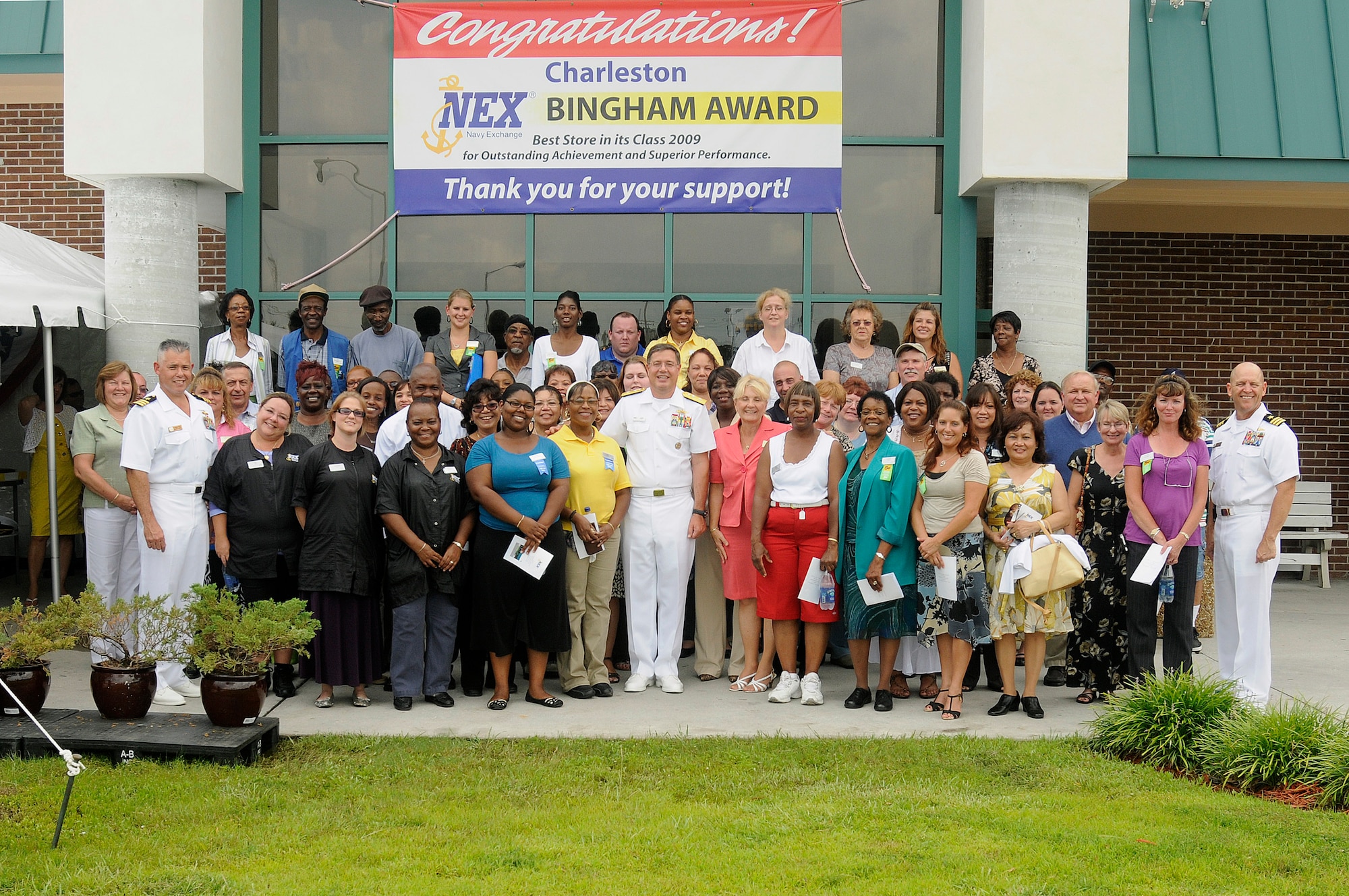 Naval Weapons Station Charleston's Navy Exchange management and employees join with distinguished guests following a ceremony awarding the Navy Exchange the Bingham Award July 15, 2010. Each year, the Bingham Award recognizes NEXs which have demonstrated excellence in customer service, operations and management. The NWS exchange placed first in the $20 to $40 million category with more than $24 million in sales for 2009. (U.S. Navy photo/Mass Communication Specialist 1st Class Jennifer Hudson/released)