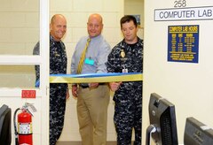 Naval Weapons Station Charleston Commanding Officer Cmdr. Gary Martin, left, Director of Military and Veteran Education Louis Martini, and Naval Consolidated Brig Charleston Commanding Officer Cmdr. Ray Drake officially open the first National Testing Center in a military prisoner correctional facility July 14, 2010, at Naval Weapons Station Charleston, S.C. The new and improved testing facility will allow military prisoners to complete accredited computer-based college level courses versus the normal paper based testing. (U.S. Navy photo/Mass Communication Specialist 1st Class Jennifer Hudson)