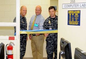 Naval Weapons Station Charleston Commanding Officer Cmdr. Gary Martin, left, Director of Military and Veteran Education Louis Martini, and Naval Consolidated Brig Charleston Commanding Officer Cmdr. Ray Drake officially open the first National Testing Center in a military prisoner correctional facility July 14, 2010, at Naval Weapons Station Charleston, S.C. The new and improved testing facility will allow military prisoners to complete accredited computer-based college level courses versus the normal paper based testing. (U.S. Navy photo/Mass Communication Specialist 1st Class Jennifer Hudson)