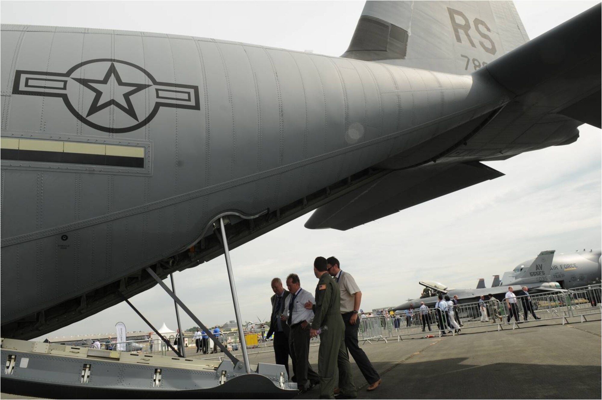 FARNBOROUGH, United Kingdom -- Capt. Samuel Bartrone, 37th Airlift Squadron pilot from Ramstein Air Base, Germany, escorts a group of spectators into the cargo bay of a C-130J Super Hercules at the 2010 Farnborough International Air Show July 20. The air show takes place July 19-25 with approximately 1,300 exhibitors from private, commercial civil and military sectors, 132,000 trade visitors and nearly 153,000 public visitors. (U.S. Air Force photo/Staff Sgt. Heather M. Norris)
