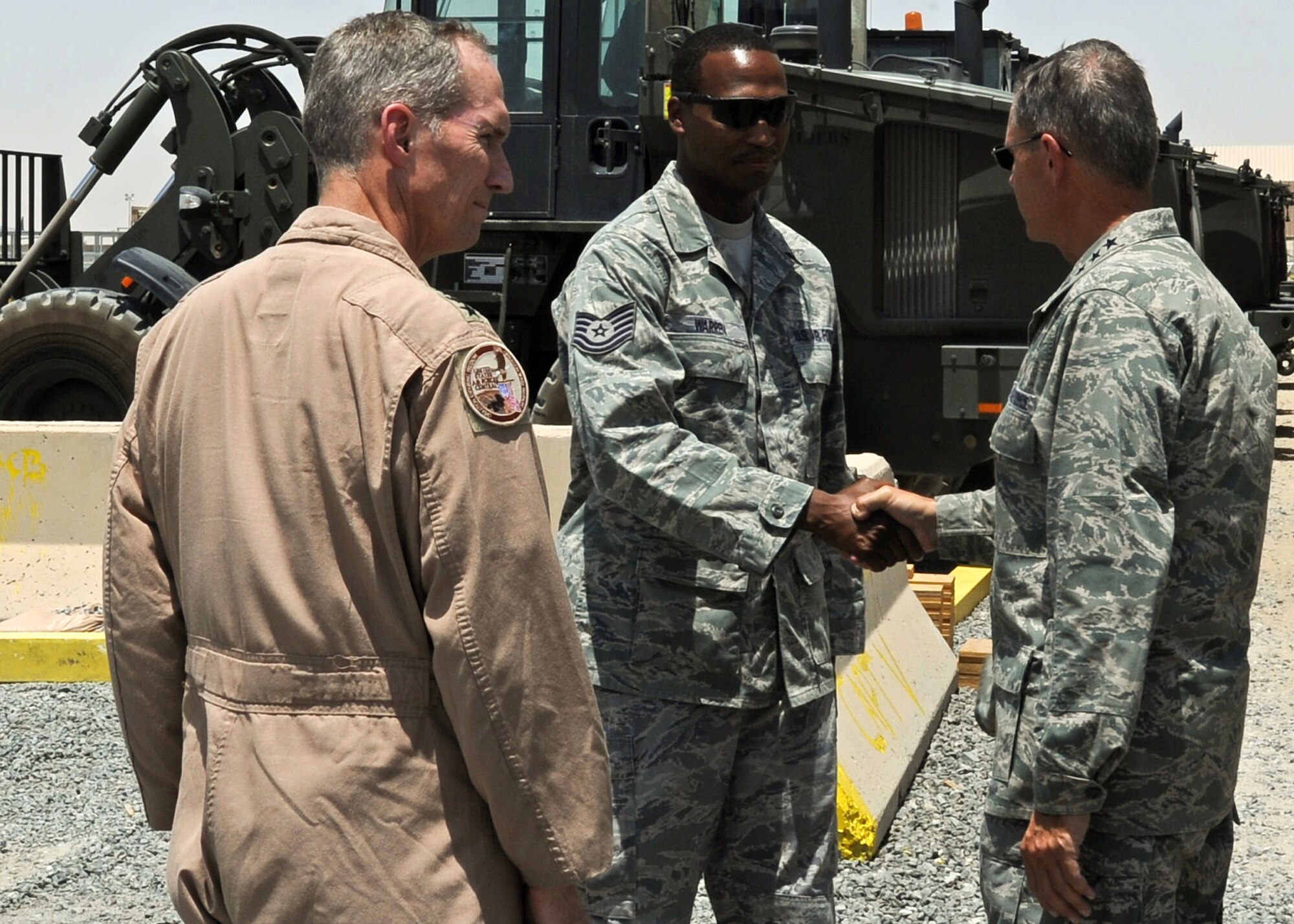 SOUTHWEST ASIA - Gen. William M. Fraser III (right), commander of Air Combat Command, greets Tech. Sgt. Darius Warren during his tour of the 386th Aerial Port Flight at an undisclosed air base here July 18, 2010. General Fraser and Lt. Gen. Mike Hostage (left), commander of U.S. Air Forces Central, got the opportunity to see the wing's Airmen at work during his tour of the base. (U.S. Air Force photo by Senior Airman Laura Turner/Released)