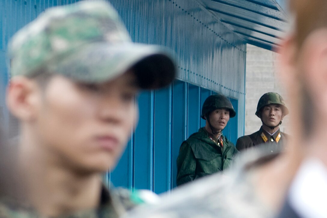 North Korean soldiers watch as South Korean Foreign Minister Yu Myung-hwan, U.S. Secretary of State Hillary Rodham Clinton, U.S. Defense Secretary Robert M. Gates and South Korean Defense Minister Kim Tae-young speak to members of the press outside the T2 buildings in Panmunjom, north of Seoul, South Korea, July 21, 2010.