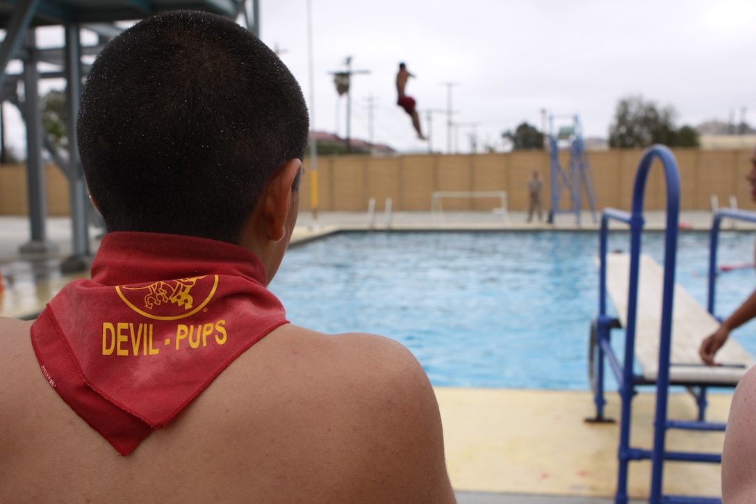 A Devil Pup recruit watches as a fellow recruit jumps from a 35-foot tower at Camp Pendleton’s 43 Area pool during the final training days of the first group for the 2010 Devil Pup program, July 22. The program is a nonprofit organization for teenagers, ages 14 to 17, teaches leadership, discipline and self confidence over a 10-day camp.