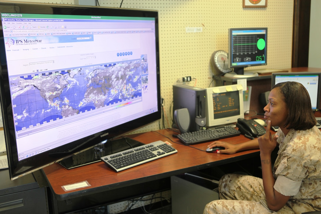 A Marine with Headquarters and Headquarters Squadron, Marine Corps Air Station New River, views a satellite image of pressure systems at the weather bureau aboard MCAS New River, July 22. The bureau monitors severe weather including hurricanes and tropical storms.