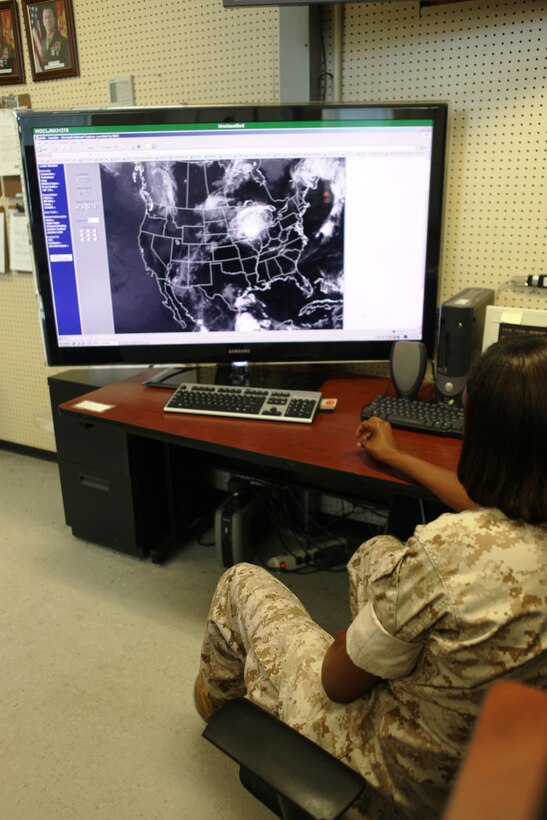 A Marine with Headquarters and Headquarters Squadron, Marine Corps Air Station New River, views a satellite image of pressure systems at the weather bureau aboard MCAS New River, July 22. The bureau monitors severe weather including hurricanes and tropical storms.