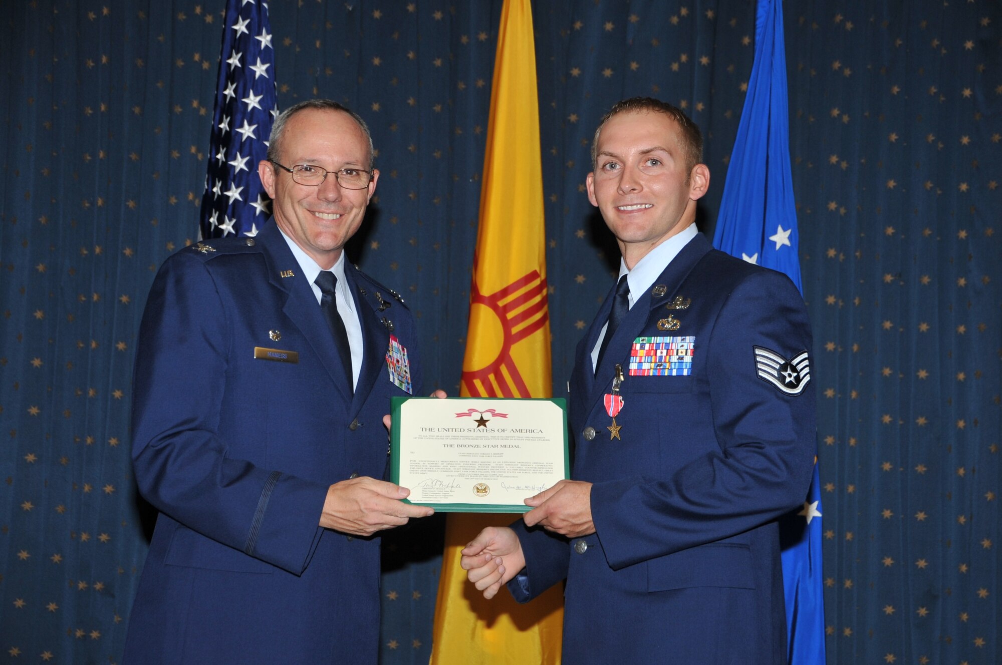 Col. Robert L. Maness, 377th Air Base Wing commander, awards Staff Sgt. Jordan Bishopp, 377th Explosive Ordnance Disposal Flight, the Bronze Star medal July 16 during a ceremony at the Mountain View Club.  U.S. Air Force Photo by Todd Berenger