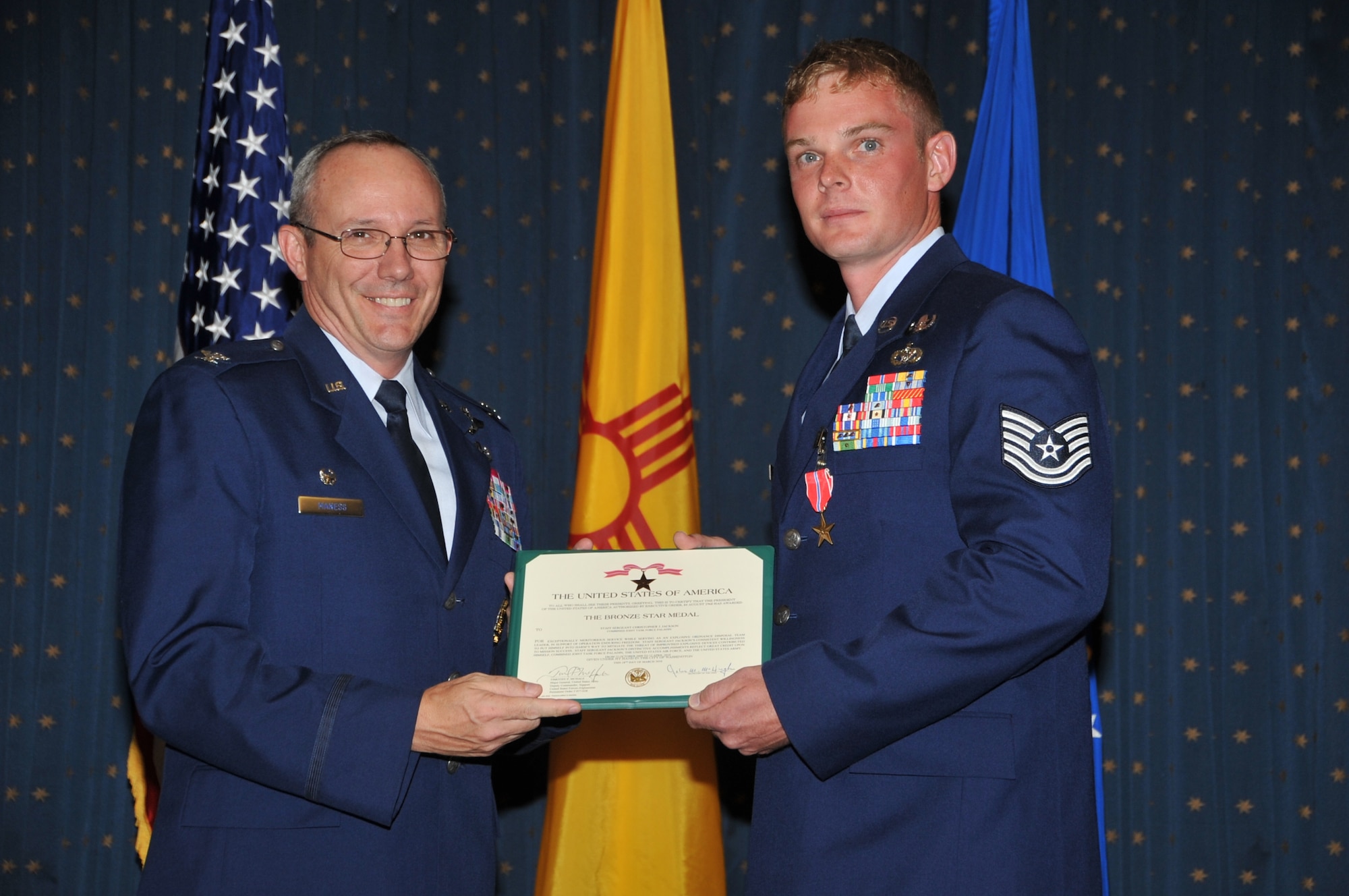Col. Robert L. Maness, 377th Air Base Wing commander, awards Tech. Sgt. Christopher J. Jackson, 377th Explosive Ordnance Disposal, the Bronze Star medal July 16 during a ceremony at the Mountain View Club. Sergeant Jackson received the medal for his actions during his recent deployment in Iraq.  U.S. Air Force Photo by Todd Berenger