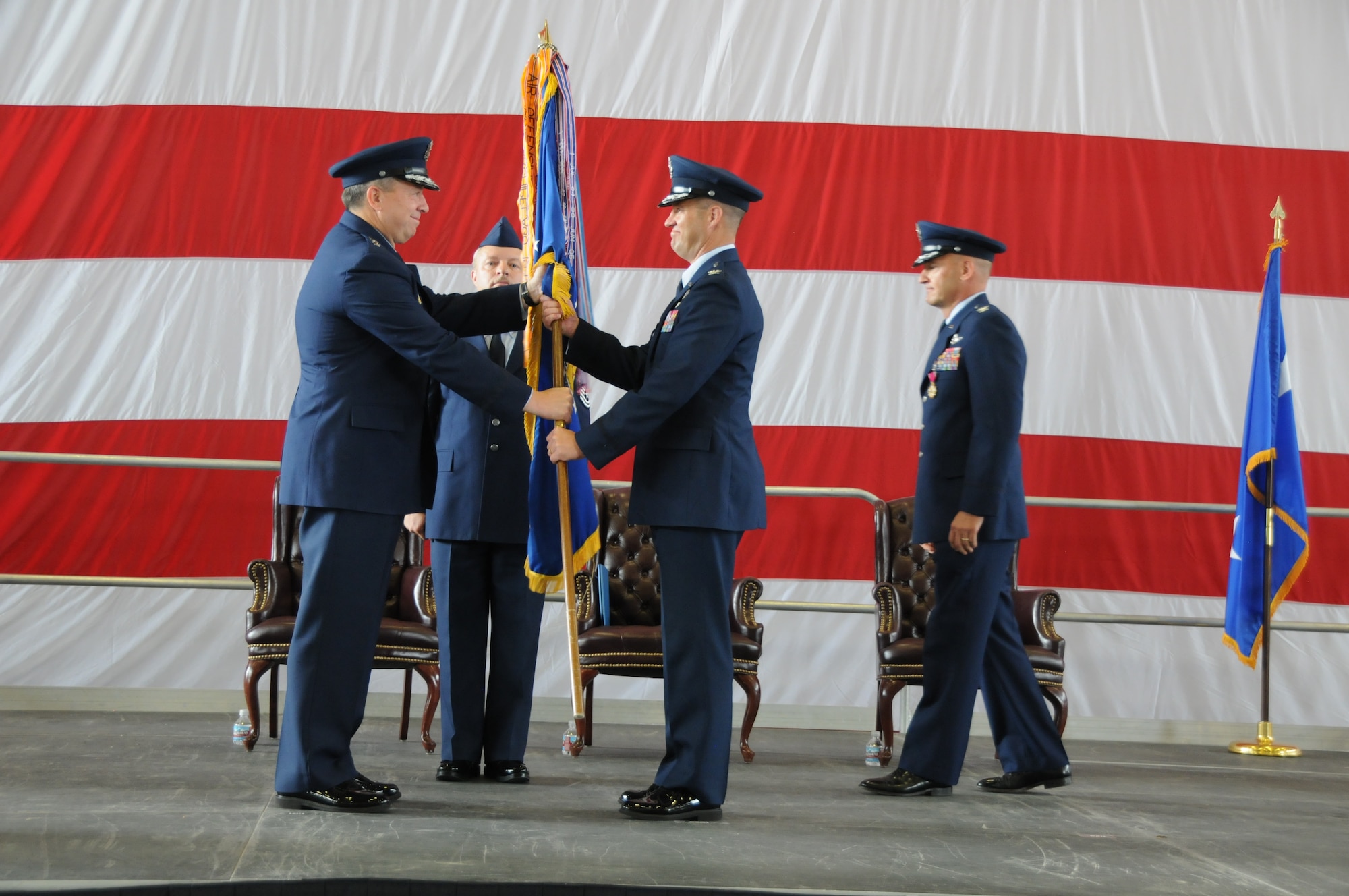 Maj. Gen. Gregory A. Feest, 19th Air Force commander, left, passes the 58th Special Operations Wing Guidon to the new commander, Col. James L. Cardoso in a change-of-command ceremony July 15 in Hangar 1000.  U.S. Air Force Photo by Dennis Carlson
