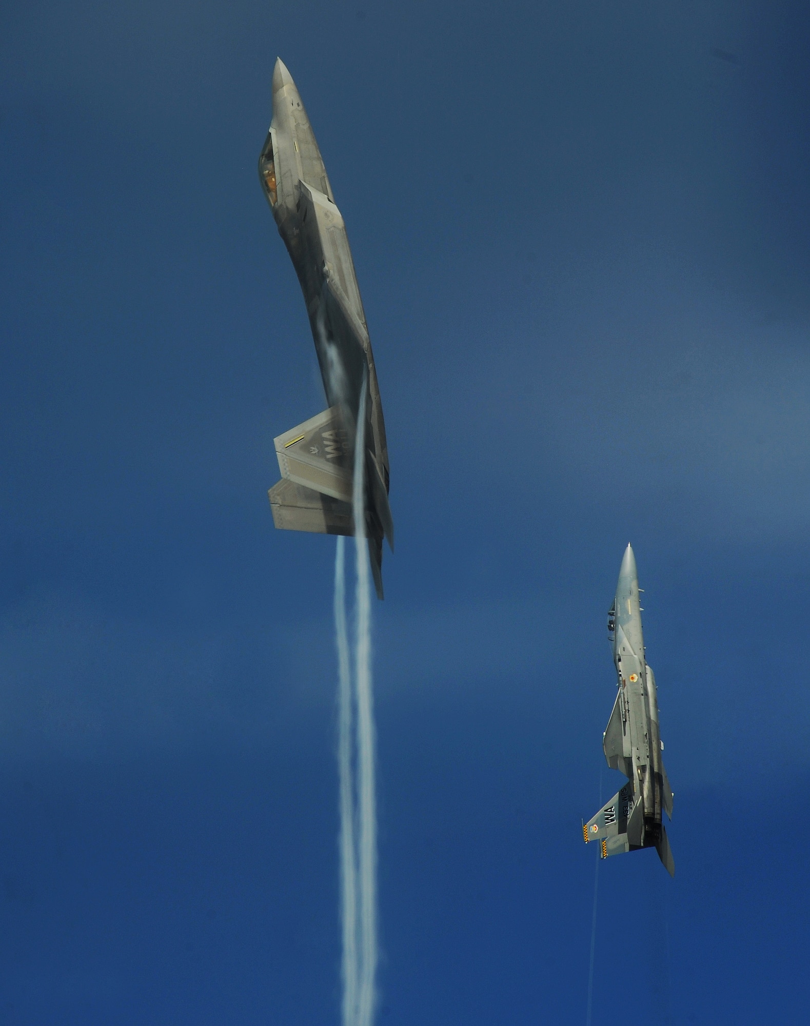 NELLIS AIR FORCE BASE, Nev.--An F-22A Raptor and F-15C Eagle from the U.S. Air Force Weapons School's 433rd Weapons Squadron pull into a vertical climb over the Nevada Test and Training Range July 16, 2010.  The NTTR is the U.S. Air Force’s premier military test and training facility with more than 12,000 square miles of airspace and 2.9 million acres of land. With 1,900 possible targets, realistic threat systems and the support of an opposing enemy force from Nellis Air Force Base, the NTTR provides the combat air force with a "peacetime battlefield" that cannot be replicated anywhere else in the world . (U.S. Air Force photo by Master Sgt. Kevin J. Gruenwald)



