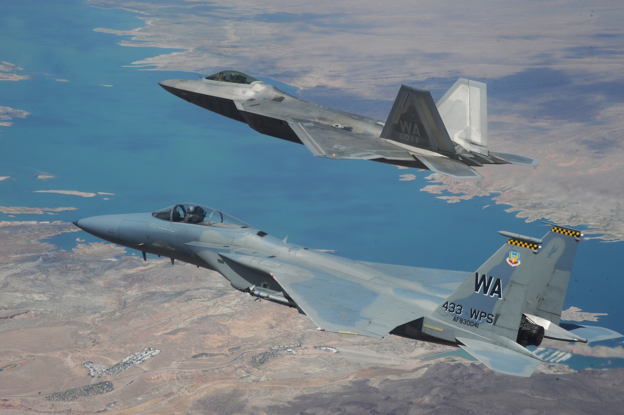 NELLIS AIR FORCE BASE, Nev.--An F-22A Raptor and F-15C Eagle from the U.S. Air Force Weapons School's 433rd Weapons Squadron fly in formation over Lake Mead, Nev., on July 16, 2010. The 433rd WPS is the only Weapons School squadron that operates two different types of aircraft.  The Weapons School began in the late 1940s as the U.S. Air Force Gunnery School and teaches graduate-level instructor courses, providing the world's most advanced training in weapons and tactics employment. (U.S. Air Force photo by Master Sgt. Kevin J. Gruenwald)


