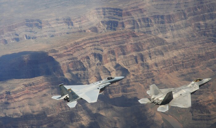 NELLIS AIR FORCE BASE, Nev.--An F-22A Raptor and F-15C Eagle from the U.S. Air Force Weapons School's 433rd Weapons Squadron fly in formation over the Grand Canyon July 16, 2010.  The 433rd WPS is the only Weapons School squadron that operates two different types of aircraft.  The Weapons School began in the late 1940s as the U.S. Air Force Gunnery School and teaches graduate-level instructor courses, providing the world's most advanced training in weapons and tactics employment. (U.S. Air Force photo by Master Sgt. Kevin J. Gruenwald)
