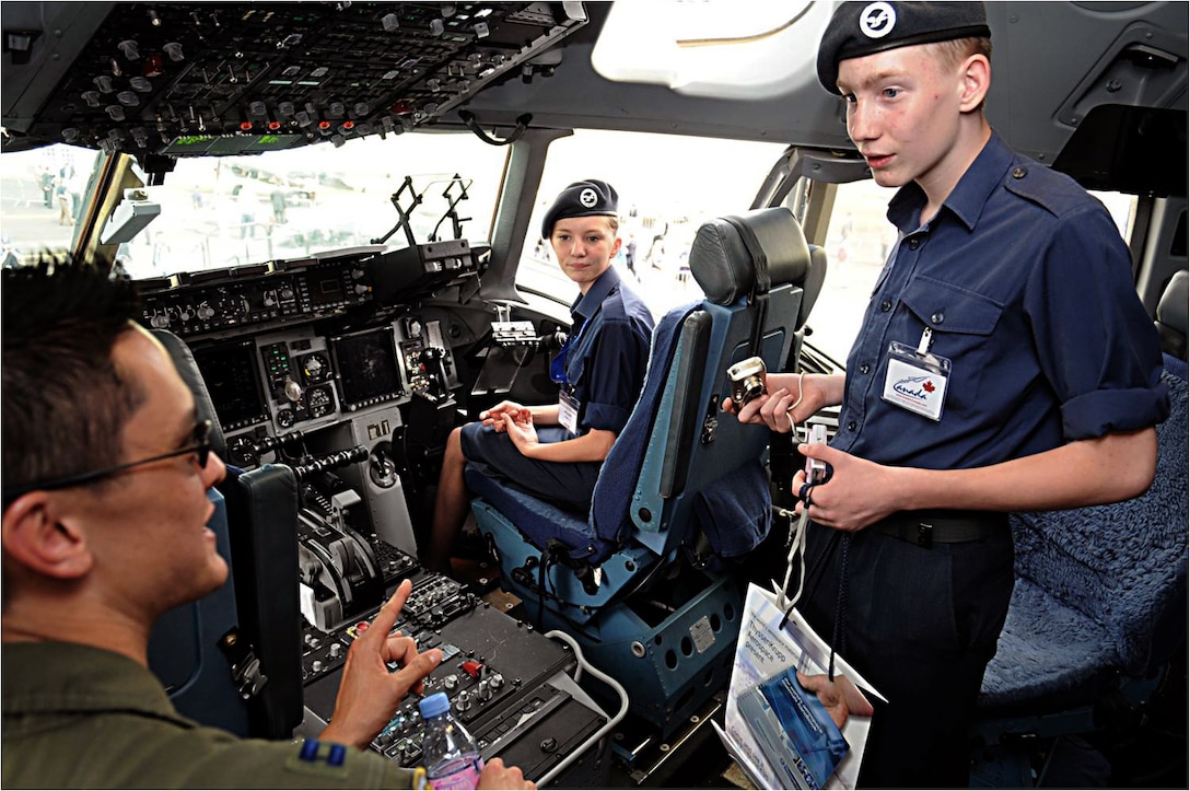 Capt. Gordon Roman (left) explains cockpit controls to British cadets July 20, 2010, in Farnborough, England. Eleven U.S. military aircraft and approximately 70 personnel representing all branches of service participate in the 2010 Farnborough International Air Show.  Captain Roman is a C-17 Globemaster III pilot from Travis Air Force Base, Calif. (U.S. Air Force photo/Staff Sgt. Jerry Fleshman) 