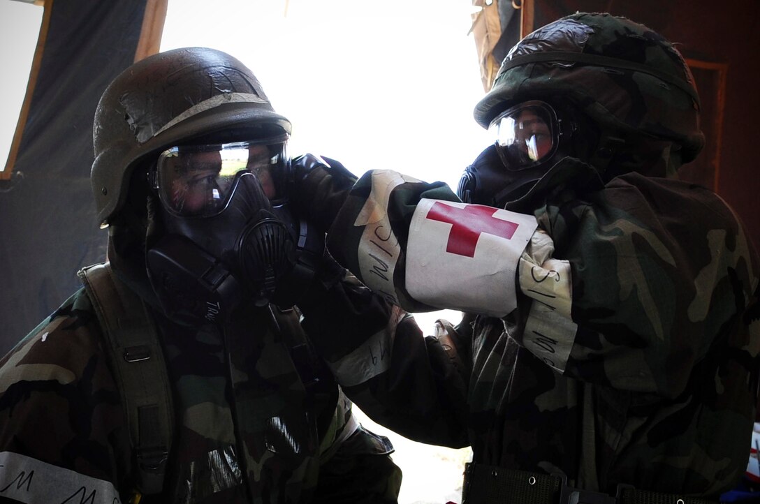 ELLSWORTH AIR FORCE BASE, S.D. – Airman 1st Class Julie Kemps, 28th Medical Operations Squadron  flight medicine technician, performs a buddy check on Airman 1st Class John Henry, 28th Medical Operations Squadron ambulance services technician, during a phase II operational readiness exercise, July 21. After donning mission-oriented protective posture gear, Airmen perform buddy checks on each other to ensure the gear is being worn properly. (U.S. Air Force photo/Airman 1st Class Corey Hook)