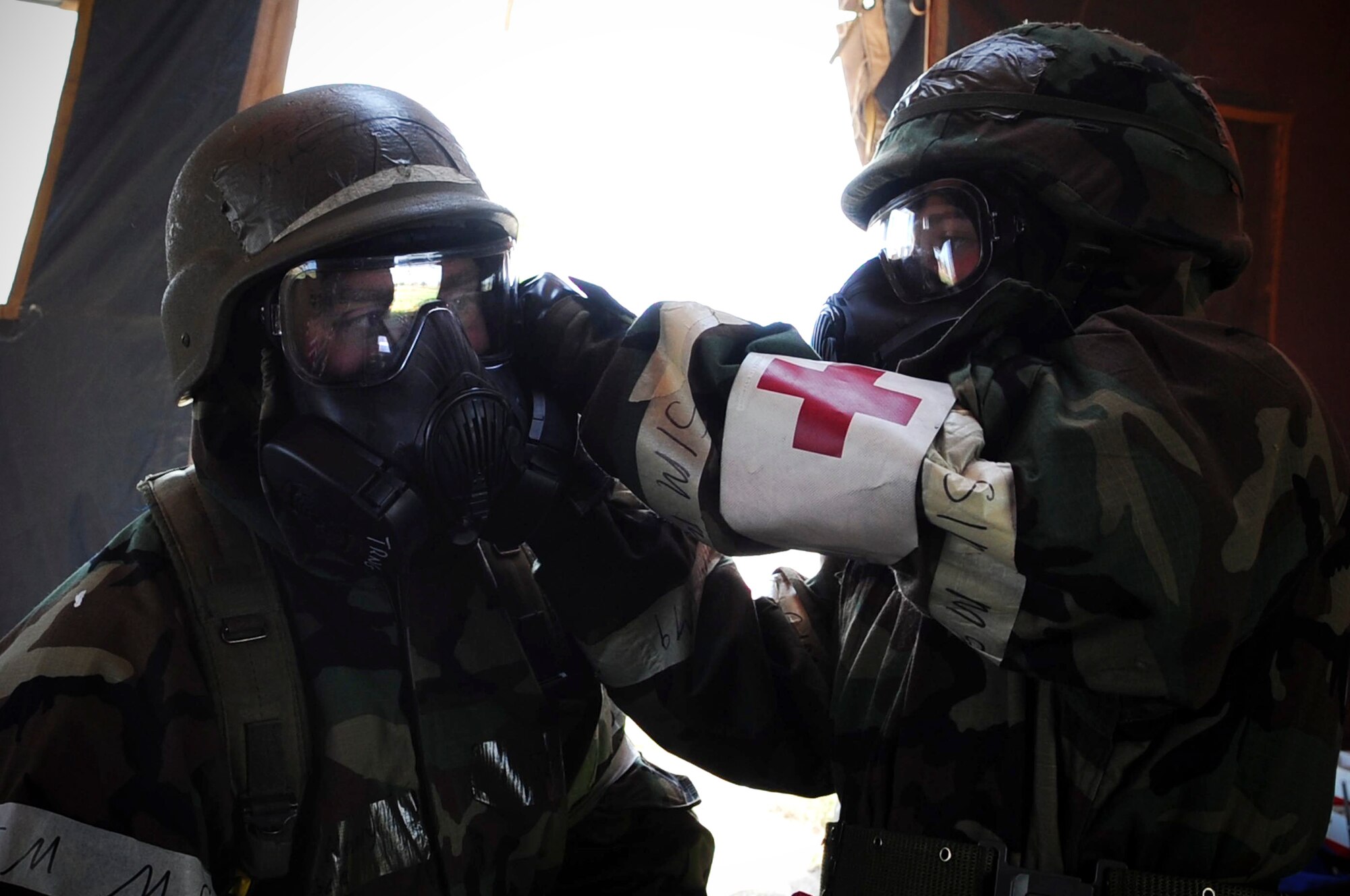 ELLSWORTH AIR FORCE BASE, S.D. – Airman 1st Class Julie Kemps, 28th Medical Operations Squadron  flight medicine technician, performs a buddy check on Airman 1st Class John Henry, 28th Medical Operations Squadron ambulance services technician, during a phase II operational readiness exercise, July 21. After donning mission-oriented protective posture gear, Airmen perform buddy checks on each other to ensure the gear is being worn properly. (U.S. Air Force photo/Airman 1st Class Corey Hook)