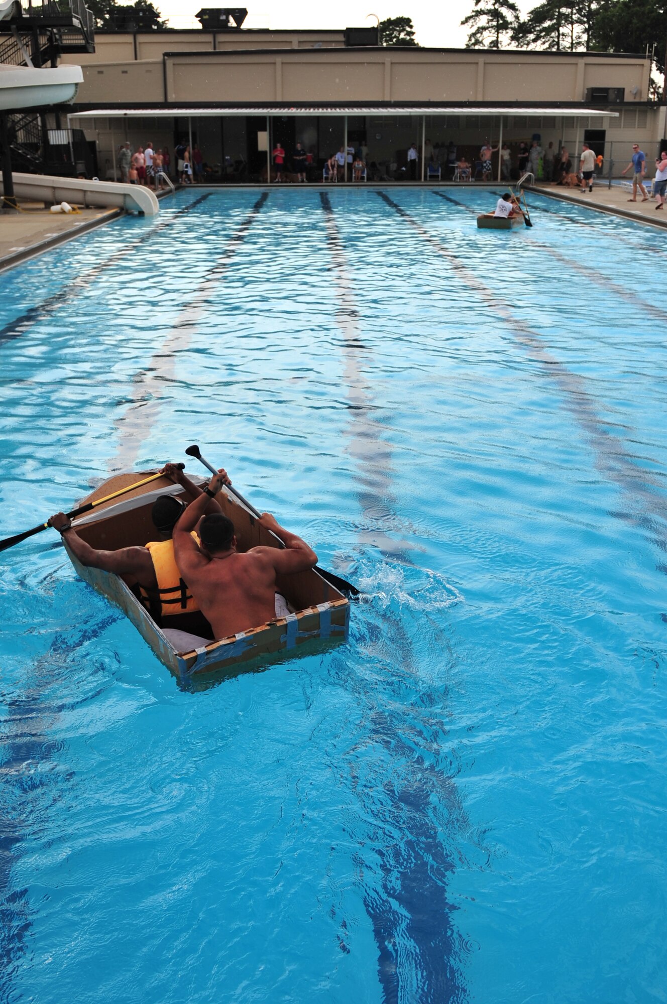 SEYMOUR JOHNSON AIR FORCE BASE, N.C. -- Tech. Sgt. Alex Willett and Staff Sgt. Chester Moore attempt to point their boat in the right direction to close the gap with the 4th Medical Group during a Build-A-Boat competition here, July 21, 2010. For the competition, teams were given three sheets of 4 feet by 10 feet cardboard, three rolls of tape, two box cutters, markers, face paint and an hour to build a sea-worthy vessel. Sergeant Willett, 4th Logistic Readiness Squadron, hails from Panama City, Panama, and Sergeant Moore, 4th LRS, is from Aiken, S.C. (U.S. Air Force photo/Senior Airman Rae Perry)