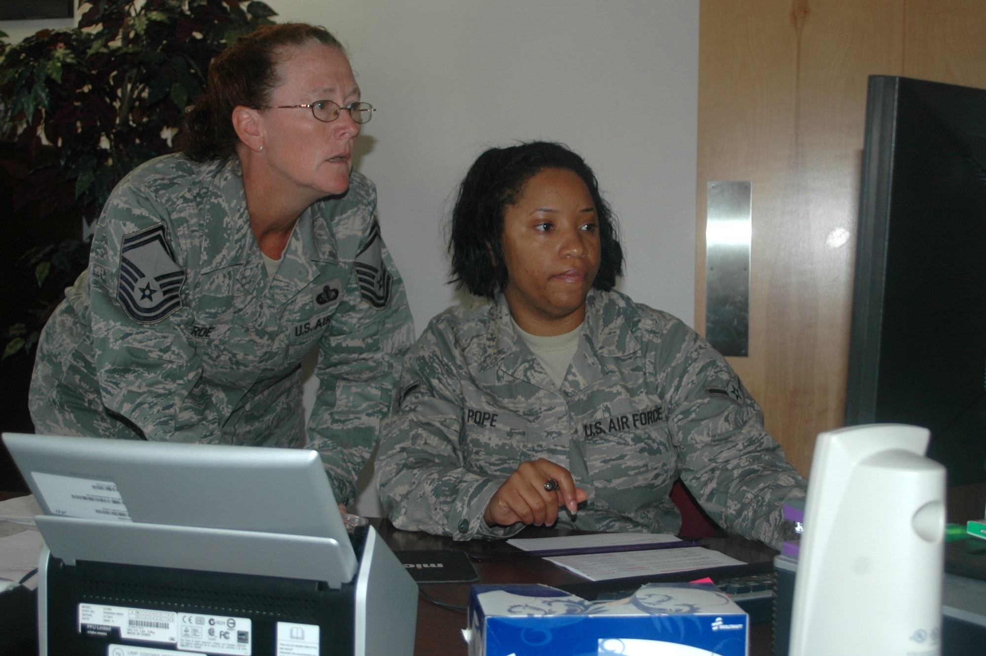 Senior Master Sgt. Raenita Monroe, (left), an air reserve technician with the 512th Memorial Affairs Squadron, Dover Air Force Base, Del., trains Airman Crystal Pope, 512th MAS, services trainee, on the automated lodging program here July 22. The program allows reservists to make their unit training assembly lodging reservations a year in advance. Sergeant Monroe and Airman Pope are two of 99 reservists assigned to the 512th MAS. (U.S. Air Force photo/Master Sgt. Jake Chappelle)
