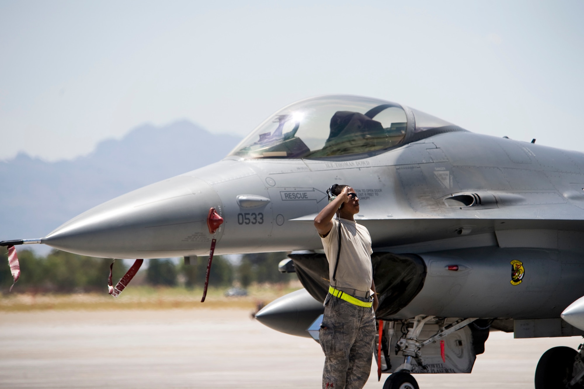 NELLIS AIR FORCE BASE, Nev.-- Airman 1st Class Terrell Dortch, crew chief, 388th Aircraft Maintenance Squadron renders a salute to his F-16 and air crew member prior to take off for a Green Flag-West 10-8 mission at Nellis on July 20, 2010. Members of Hill Air Force Base's 4th Fighter Squadron trained with the U.S. Army in realistic air-land integration scenarios at the National Training Center, Fort Irwin, Calif., July 11-23. The 4th FS is preparing for upcoming deployment to Afghanistan in in support of counter-insurgency operations. (U.S. Air Force photo by Lawrence Crespo)
