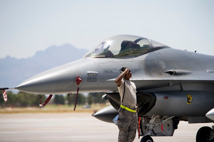 NELLIS AIR FORCE BASE, Nev.-- Airman 1st Class Terrell Dortch, crew chief, 388th Aircraft Maintenance Squadron renders a salute to his F-16 and air crew member prior to take off for a Green Flag-West 10-8 mission at Nellis on July 20, 2010. Members of Hill Air Force Base's 4th Fighter Squadron trained with the U.S. Army in realistic air-land integration scenarios at the National Training Center, Fort Irwin, Calif., July 11-23. The 4th FS is preparing for upcoming deployment to Afghanistan in in support of counter-insurgency operations. (U.S. Air Force photo by Lawrence Crespo)

