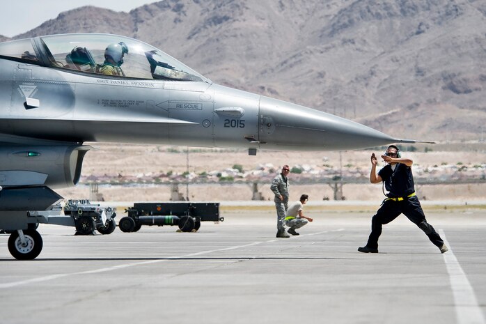 NELLIS AIR FORCE BASE, Nev.-- Senior Airman Norman Rollock, crew chief, 388th Aircraft Maintenance Squadron, Hill Air Force Base, Utah, marshals an F-16 to the taxiway at Nellis during a Green Flag-West 10-8 mission July 20, 2010.  The 388th Fighter Wing trained with the U.S. Army in realistic air-land integration scenarios at the National Training Center, Fort Irwin, Calif., July 11-23. The wing is preparing for upcoming deployment to Afghanistan in in support of counter-insurgency operations. (U.S. Air Force photo by Lawrence Crespo)

