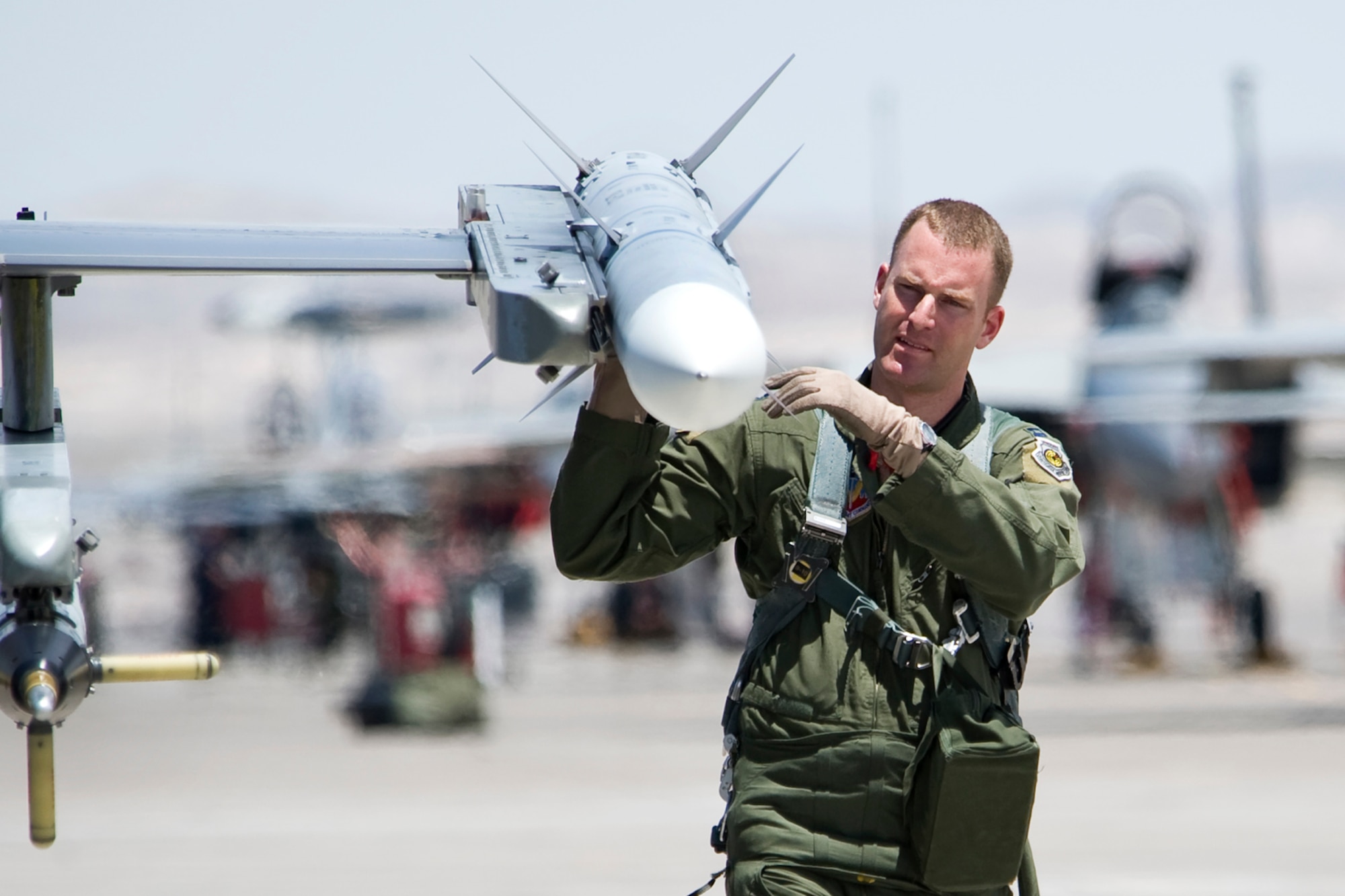 NELLIS AIR FORCE BASE, Nev.-- Capt. Mike Seltzer, an F-16 assigned to the 4th Fighter Squadron, Hill Air Force Base performs a pre-flight inspection on an AIM-120 Advanced Medium-Range Air-to-Air Missile prior to his participation in Green Flag West 10-8 exercise at Nellis on July 20.  

Green Flag-West provides a realistic air-land integration training environment for Airmen and Soldiers preparing to deploy in support of worldwide combat operations. (US Air Force Photo by Lawrence Crespo)
