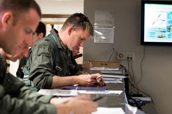 NELLIS AIR FORCE BASE, NEV.-- Capt. Paul Doughty,(center) F-16 pilot, 4th Fighter Squadron, Hill Air Force Base and fellow crew members review flight plan information prior to take off during Green Flag-West 10-8, at Nellis on July 20.   Green Flag exercises provide a realistic air-land integration training environment for Airmen and Soldiers preparing to deploy in support of worldwide combat operations. (US Air Force Photo by Lawrence Crespo)