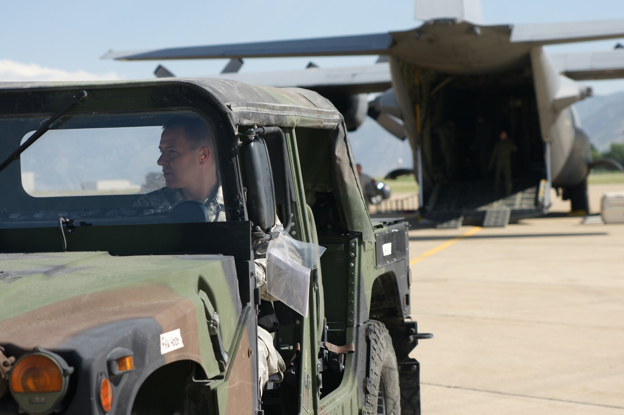 Tech. Sgt. Brent Barney, 67th Aerial Port Squadron, drives a humvee directly out from the loading ramp of a C-130 aircraft July 11. He stayed 300 feet behind the aircraft to clear the hazardous zones of the C-130’s jet blast. (U.S. Air Force photo/Staff Sgt. Alan Schultz)