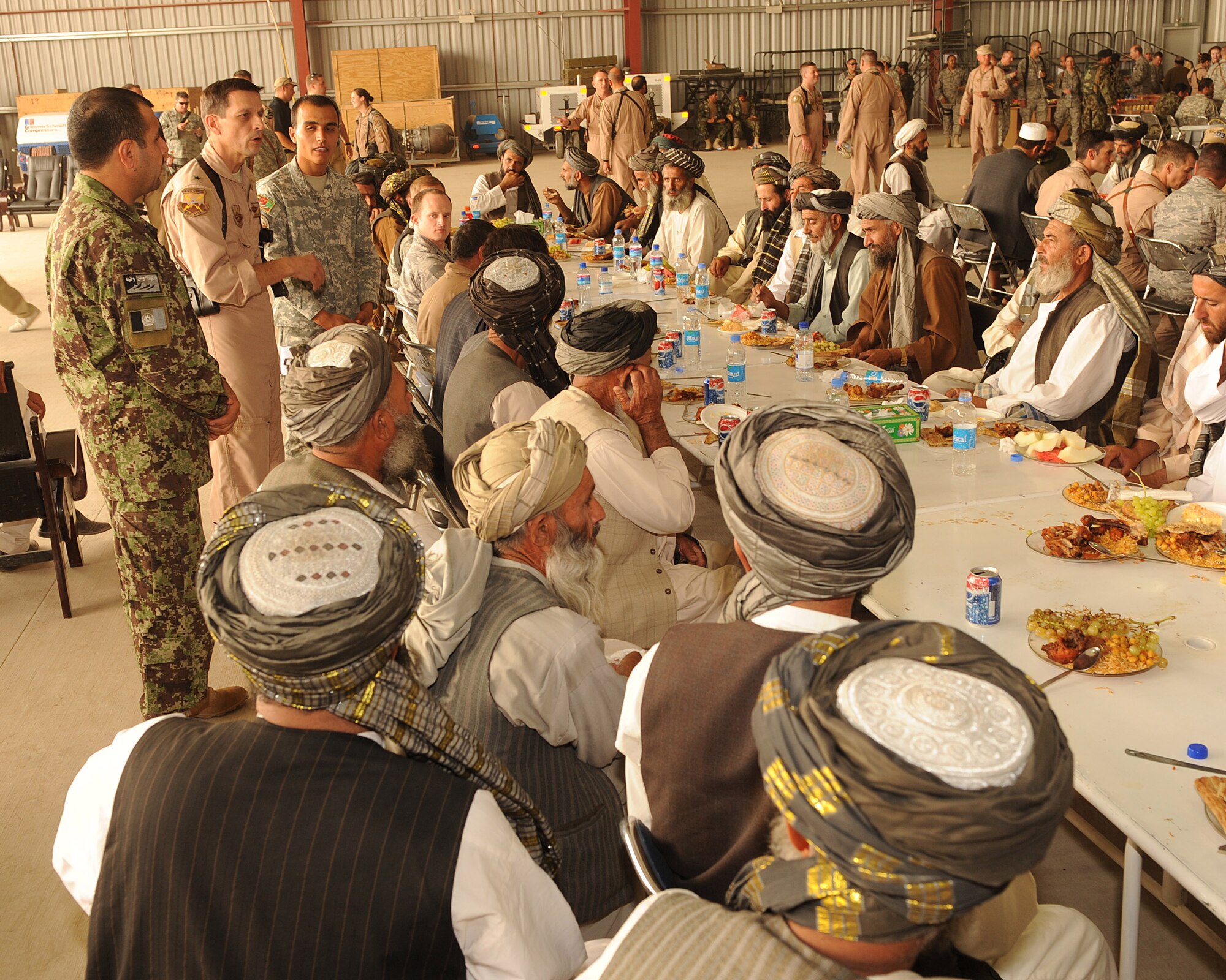 Brig. Gen. Paul Johnson, 451st Air Expeditionary Wing commander, speaks with Kandahari elders following a change-of-command ceremony at Kandahar Airfield, Afghanistan, July 21, 2010.  Afghan Airmen hosted the ceremony at the Afghan Air Force hangar to showcase the partnership between the Kandahar Air Wing and the 451 AEW.    (U.S. Air Force Photo by Staff Sgt. Chad Chisholm/Released)