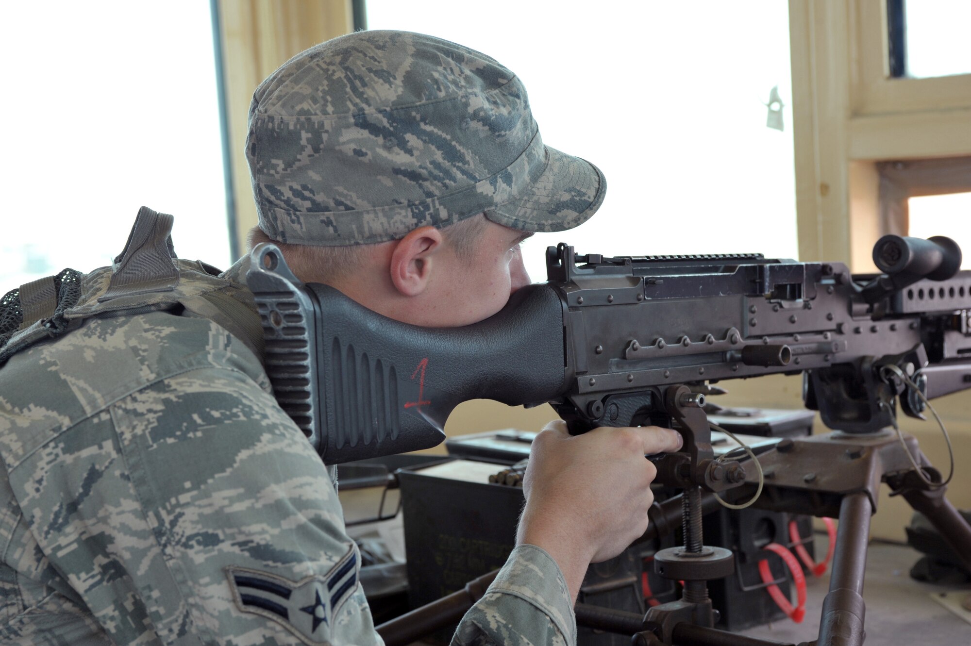Senior Airman Taylor Scott, 380th Expeditionary Security Forces Squadron journeyman, peers down the site of his tri-pod mounted M240B July 22 at an undisclosed location in Southwest Asia.  Security Forces Airmen are responsible for securing more than 300 acres of land.  (U.S. Air Force photo/Tech. Sgt. April Wickes)