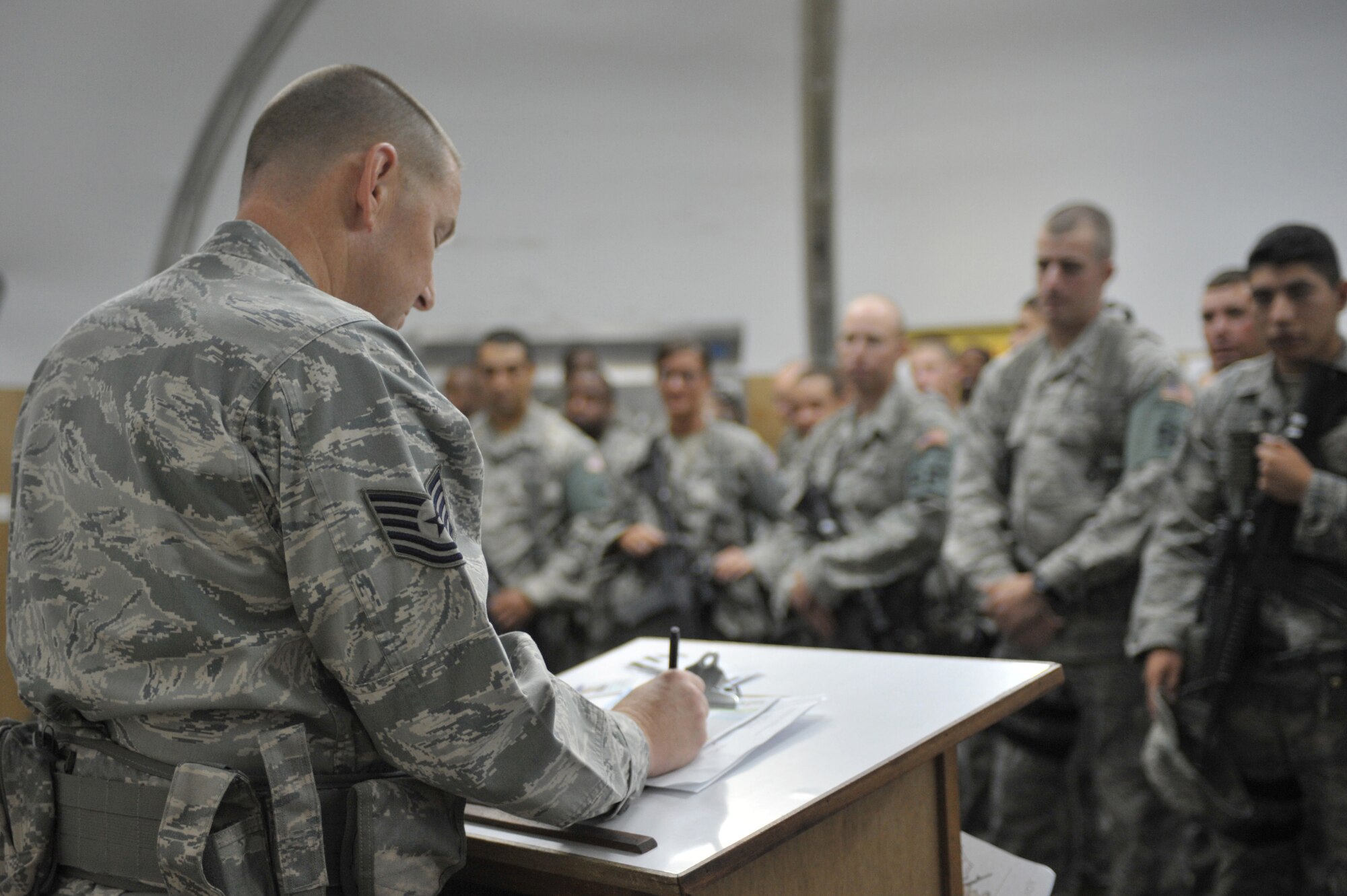 Tech. Sgt. Alex Bell, 380th Expeditionary Security Forces Squadron A flight chief, conducts roll-call during guard mount July 22 at an undisclosed location in Southwest Asia.  Security Forces Airmen are responsible for securing more than 300 acres of land.  (U.S. Air Force photo/Tech. Sgt. April Wickes)