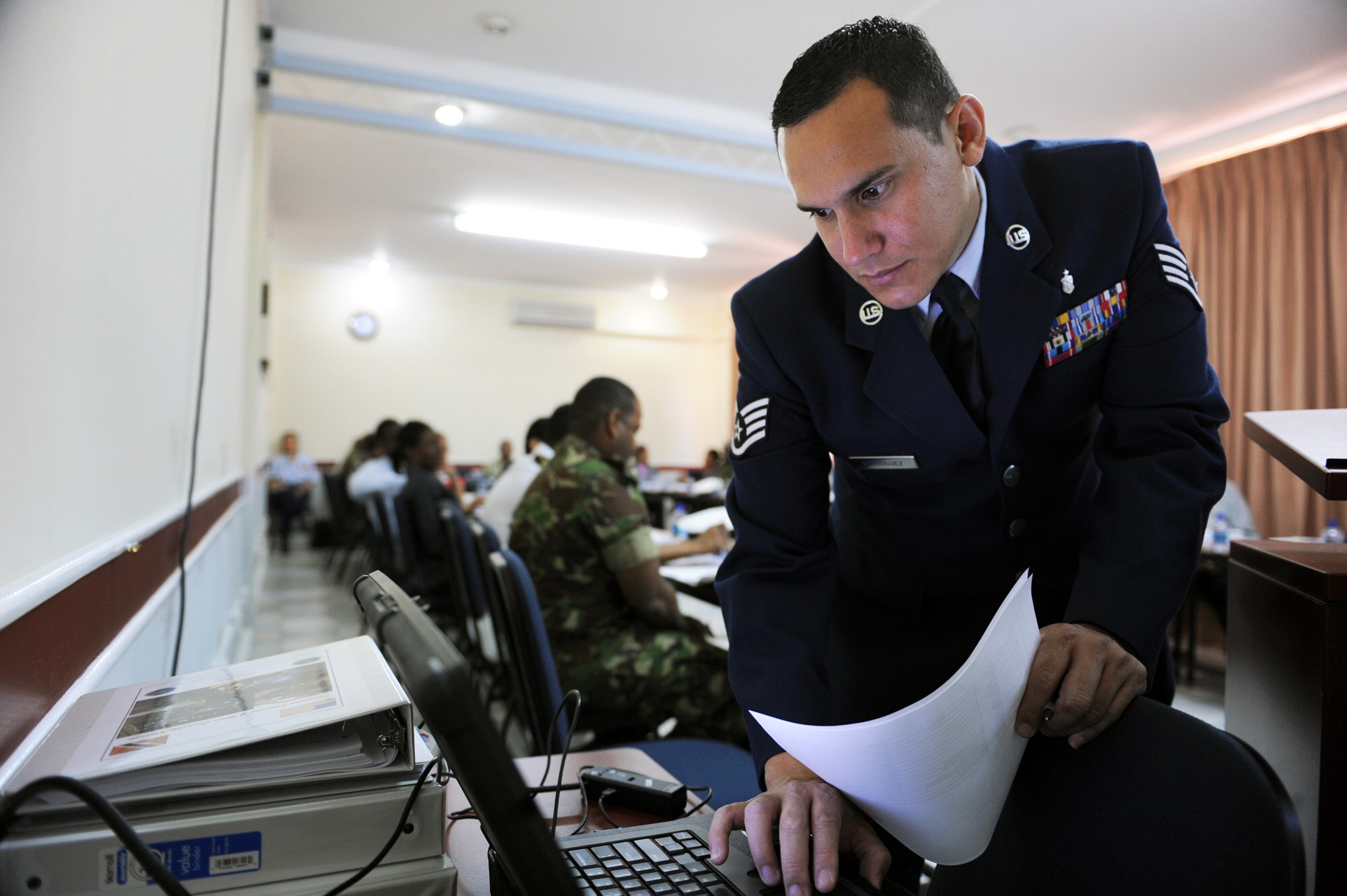 Staff Sgt. Abraham Rodriguez loads a slideshow onto a computer before he teaches a disaster planning and mass casualty response class for primary care providers July 19, 2010, in Port of Spain, Trinidad and Tobago. Sergeant Rodriguez is the NCO in charge of the Defense Institute for Medical Operations, United States Air Force School of Aerospace Medicine, at Brooks City-Base, Texas. (U.S. Air Force photo/Staff Sgt. Desiree N. Palacios)