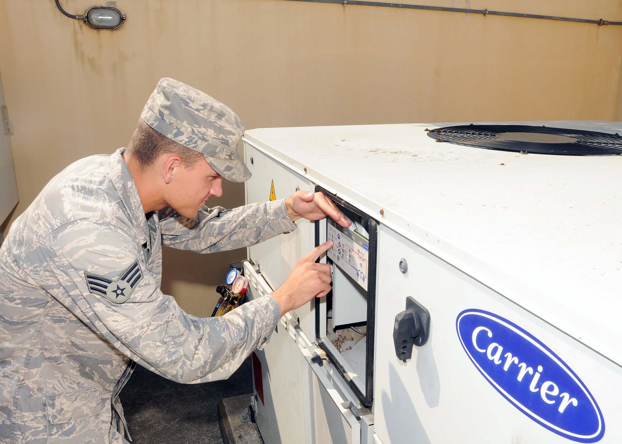 Senior Airman Jeremy McNeely, 31st Civil Engineer Squadron heating, ventilation, air conditioning and refrigeration journeyman, reads the display board of an air conditioning unit outside a dormitory complex July 21.  This board gives HVAC/R Airmen the status of the machine and warnings when there is a problem.  (U.S. Air Force photo/Senior Airman Tabitha M. Lee)