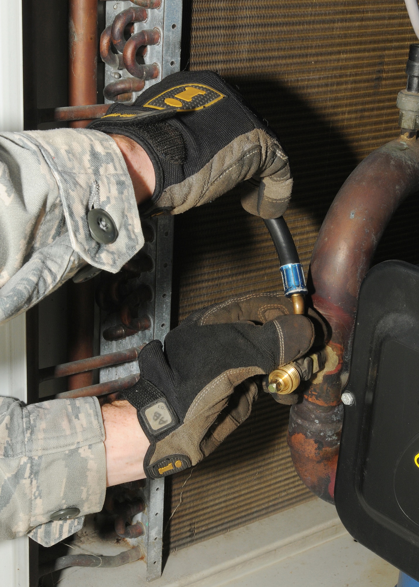 Airman 1st Class Corey Willis, 31st Civil Engineer Squadron heating, ventilation, air conditioning and refrigeration apprentice, attaches a manifold gauge assembly to an air conditioning unit outside a dormitory complex July 21.  The HVAC/R team is responsible for all air conditioning and heating units within the dormitories, Base Exchange, Commissary, and all work centers around the base.  (U.S. Air Force photo/Senior Airman Tabitha M. Lee)