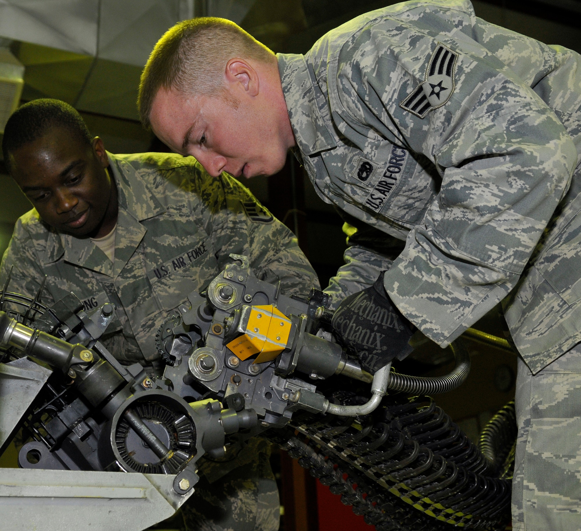 Staff Sgt. Michael Armstrong and Senior Airman Joseph Churchwell, 332nd Expeditionary Maintenance Squadron aircraft armament technicians, attach a loader head to a test stand for operational tests July 17, 2010, Joint base Balad, Iraq. The loader head is the interface for loading rounds into an M-61A1 20mm multi-barrel cannon. Sergeant Armstrong is a native of Georgetown, S.C. and Airman Churchwell is a native of Greenville, S.C. Both are deployed from Shaw Air Force Base, S.C. (Air Force photo/Staff Sgt. Phillip Butterfield)