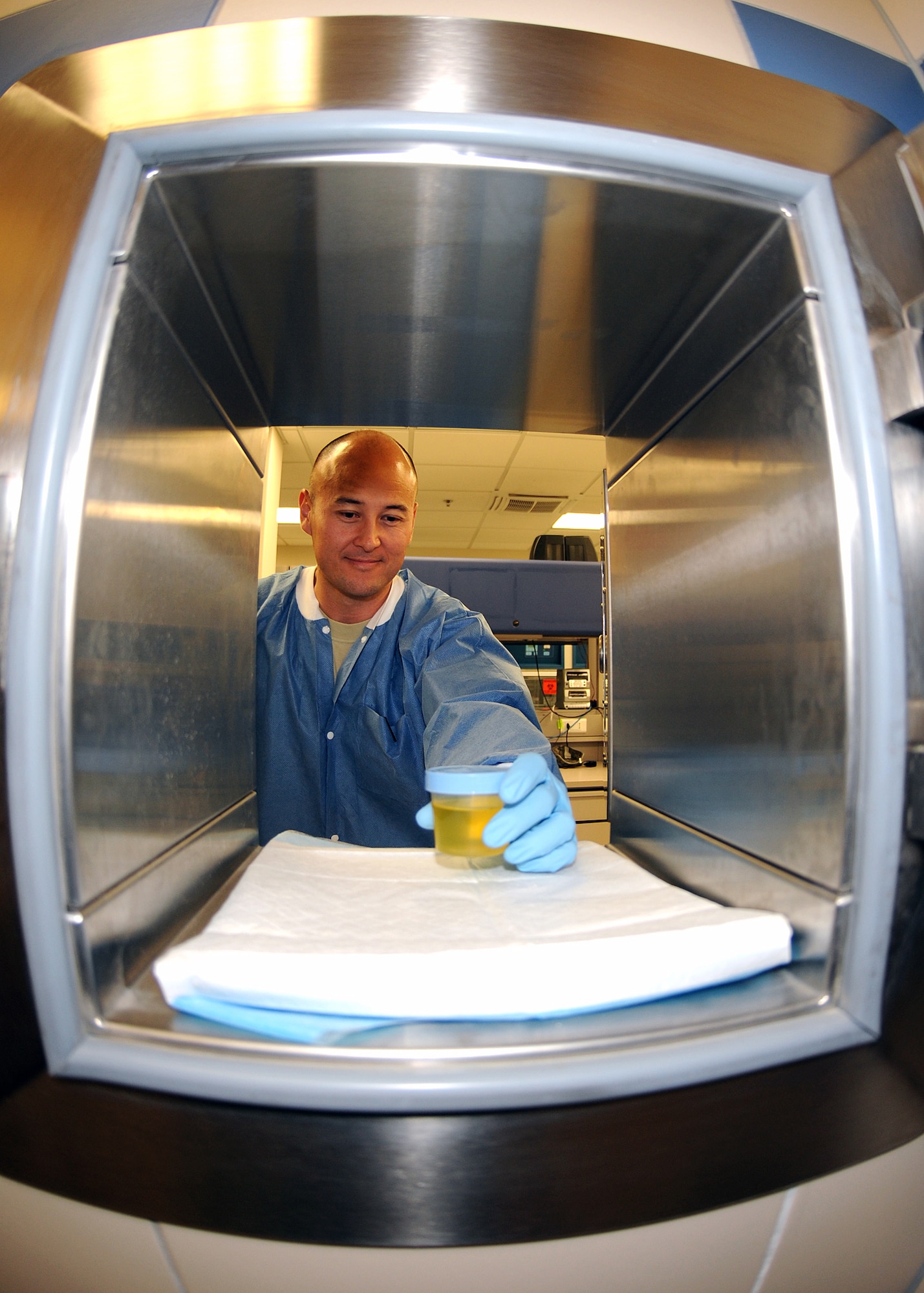 Master Sgt. Eric Stubbs, 31st Medical Support Squadron noncommissioned officer in charge, collects a urine sample from a window July 20 at the medical laboratory.  The laboratory performs various functions such as hematology, clinical chemistry and microbiology.  (U.S. Air Force photo/Senior Airman Tabitha M. Lee)