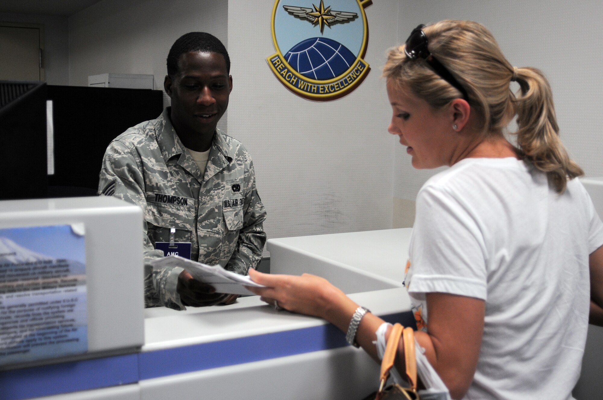 YOKOTA AIR BASE, Japan -- Senior Airman Antoine Thompson, 730 Air Mobility Command passenger service agent, answers questions for Mrs. Meredith Merrill, wife of Capt. Fred Merrill, 374 Operations Group executive, about the Space-A (space available) program here July 22. The Space-A program is meant as a way to help lessen the burden and expenses of traveling. (U.S. Air Force photo/ Airman 1st Class Katrina R. Menchaca)