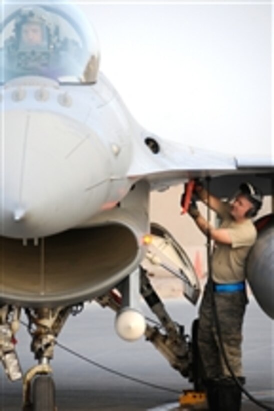 U.S. Air Force Senior Airman Jaymes Russell, a crew chief with the 169th Aircraft Maintenance Squadron, McEntire Joint National Guard Base, S.C., prepares an F-16 Fighting Falcon aircraft to fly a mission from Joint Base Balad, Iraq, on July 7, 2010.  Pilots and maintenance personnel from various units deployed to Joint Base Balad with the 169th Fighter Wing to cover an Air Expeditionary Force deployment.  