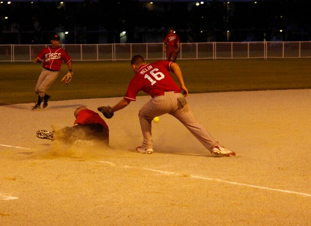 Marine Wing Support Squadron 171 third baseman Brian Melin attempts to tag out a Headquarters and Headquarters Squadron Team Torii base runner during an intramural softball playoff game at the main softball field here July 22. Team Torii was able to out run, out hit, and out field the rest of the league, making them the 2010 Intramural Softball champions.