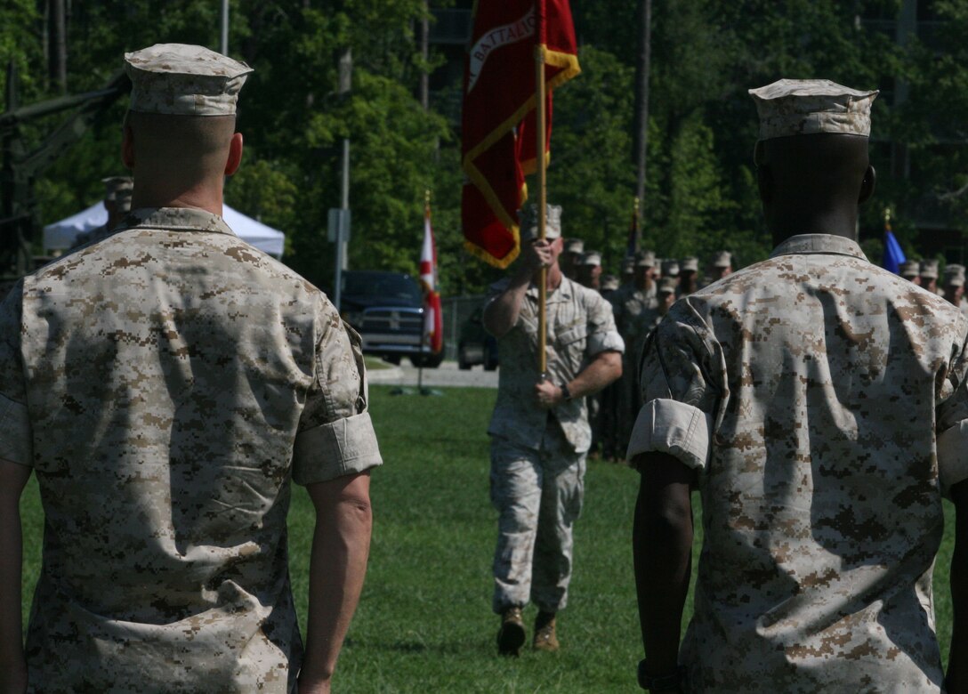 Lieutenant Col. Desmond A. Reid (right), the outgoing commanding officer of 8th Communication Battalion, and Lt. Col. Michael B. Schweighardt, the incoming commanding officer of 8th Comm, await the battalion guidon during a change of command aboard Marine Corps Base Camp Lejeune, N.C., July 22, 2010.