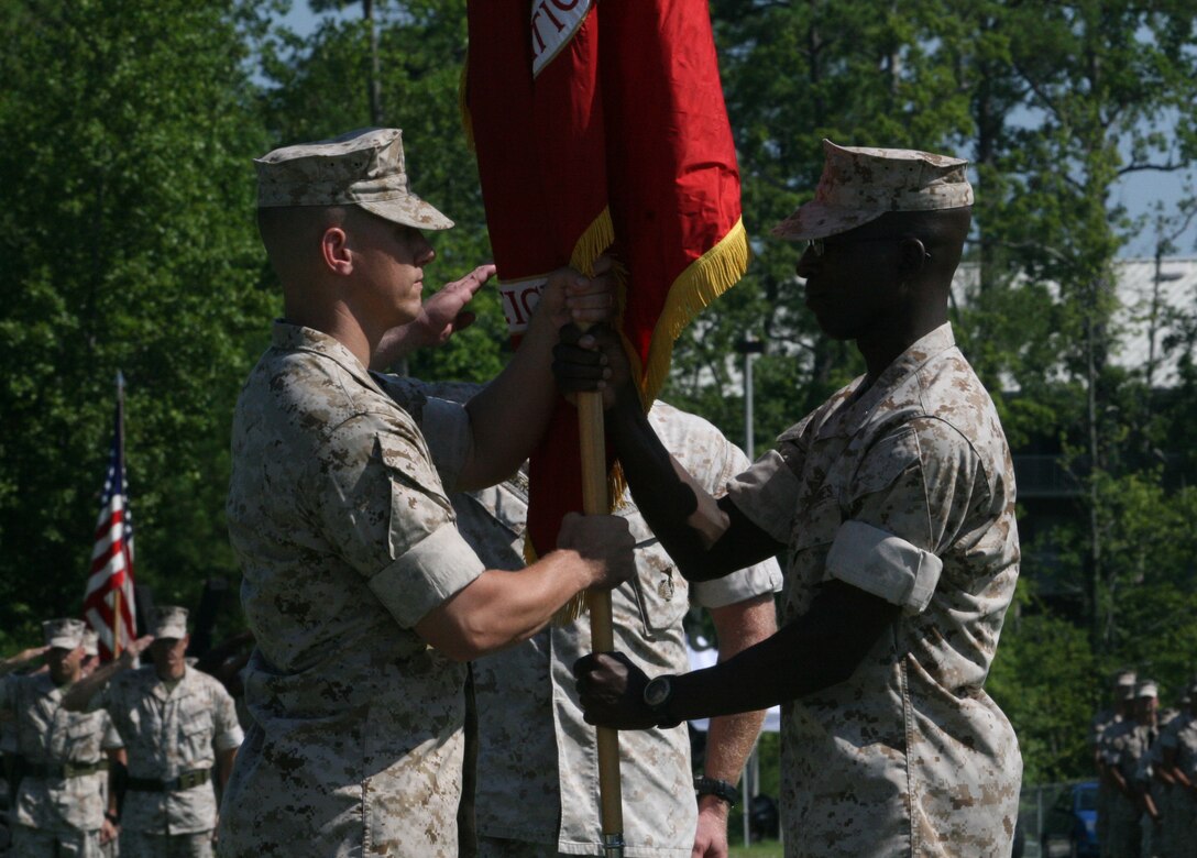 Lieutenant Col. Desmond A. Reid (right), the outgoing commanding officer of 8th Communication Battalion,  passes the battalion guidon to Lt. Col. Michael B. Schweighardt, the incoming commanding officer of 8th Comm, during a change of command ceremony aboard Marine Corps Base Camp Lejeune, N.C., July 22, 2010.