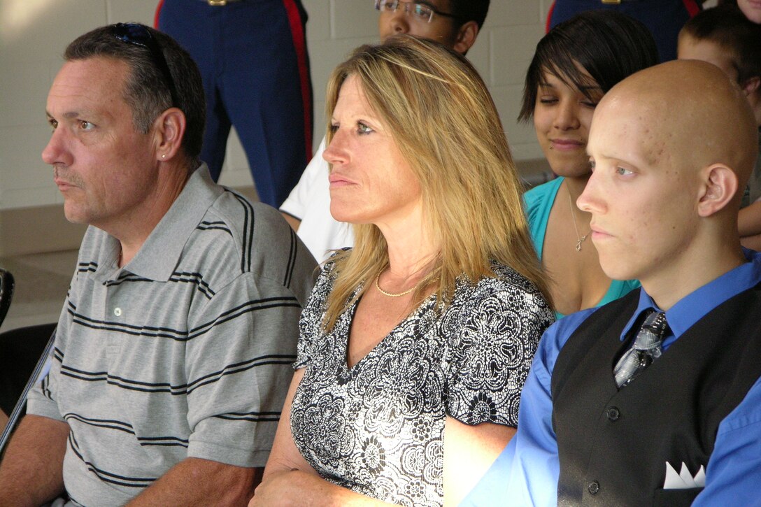 Former Marine poolee Derrick Owen (right) sits with his mother Tammy Owen and his step-father Douglas Denny during a ceremony naming Derrick Owen an Honorary Marine July 23. Owen was diagnosed with Rhabdomyosarcoma, a rare form of cancer that attacks tissue and bone, in January while in the Marine Corps Delayed Entry Program during his senior year of high school.