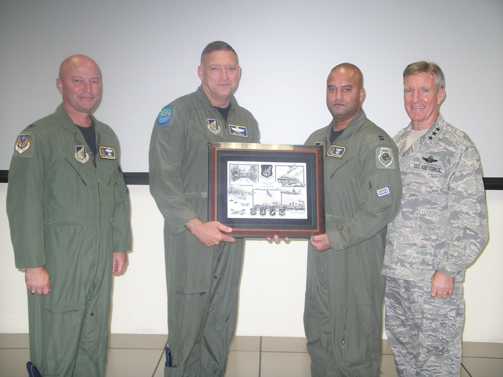 Capt. Raj Agrawal, from the 613th Air and Space Operations Center, Hickam Air Force Base, accepts an award from Gen. Gary North, the Pacific Air Forces commander, left, and Lt. Gen. Hawk Carlisle commander, 13th Air Force, right. Captain Agrawal, now executive officer to the commander, was selected from more than 2,250 PACAF company grade officers based on his military performance while 613th AOC chief of space operations and missile defense.(Courtesy photo)