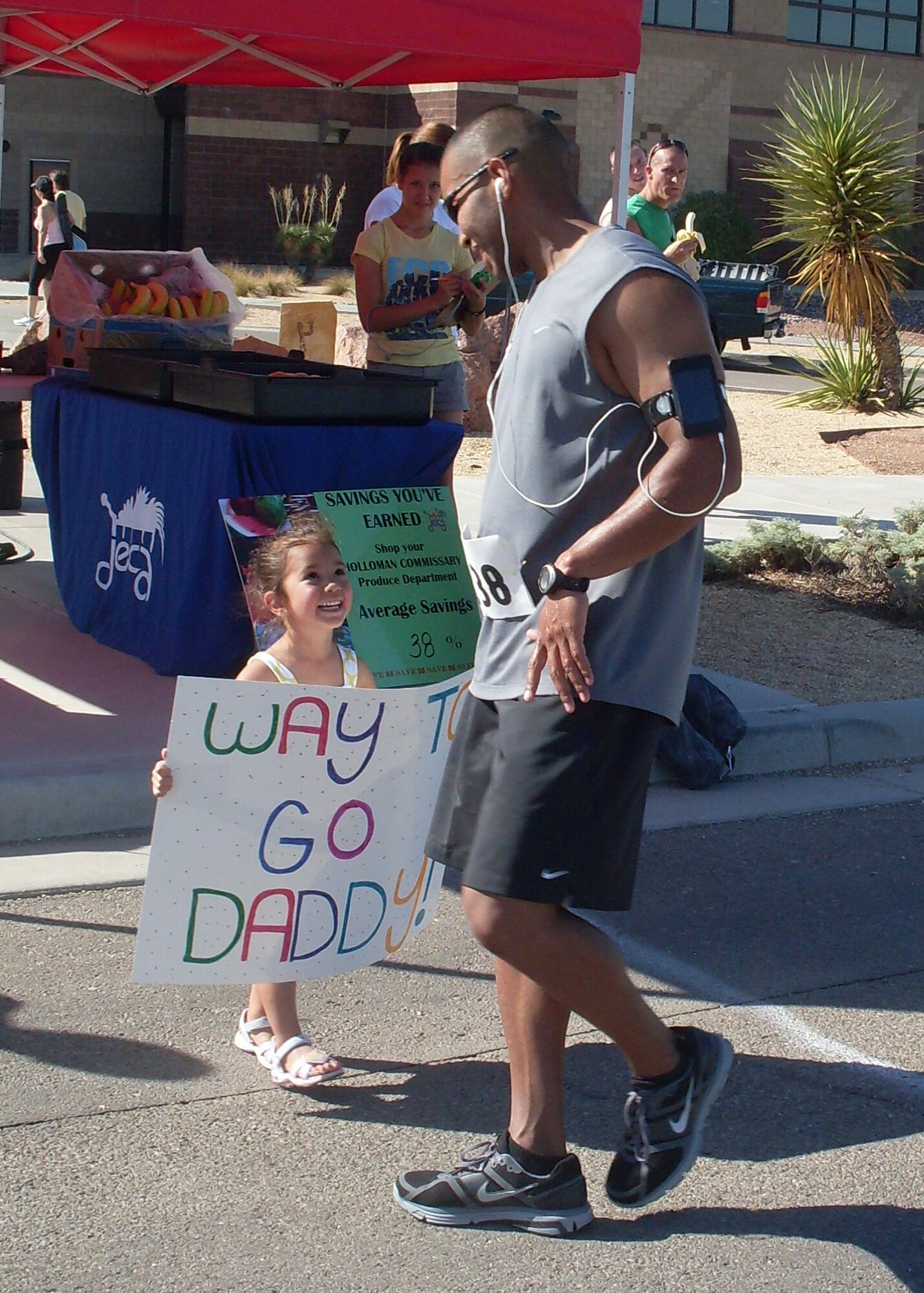 HOLLOMAN AIR FORCE BASE, N.M. -- Staff Sgt. Daniel Flores, 49th Security Forces Squadron Military Working Dog flight, is greeted at the finish line by his daughter, Ryleigh Flores, during the Half Marathon at the Domenici Fitness and Sports Center July 17, 2010. Participants had to run a total of 13.2 miles, and upon completion complimentary refreshments were provided by the Commissary. (Courtesy photo)
