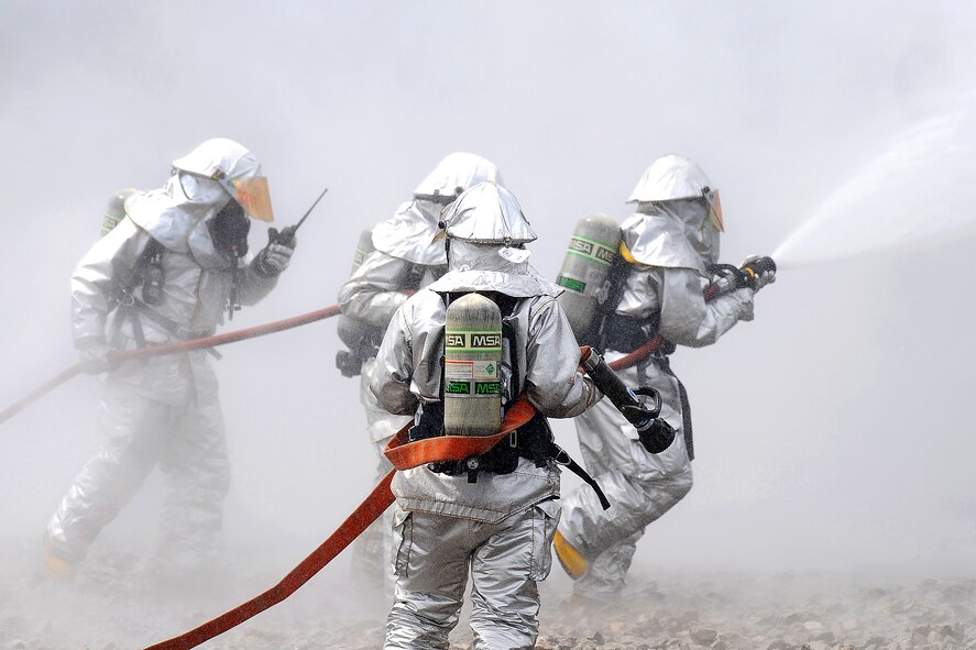 Firefighters battle the smoke during a live fire response exercise July 21, 2010, at the Combat Readiness Training Center in Alpena, Mich. The firefighters are with the Michigan Air National Guard's 127th Wing at Selfridge Air National Base.   (U.S. Air Force photo/Master Sgt. Terry Atwell)