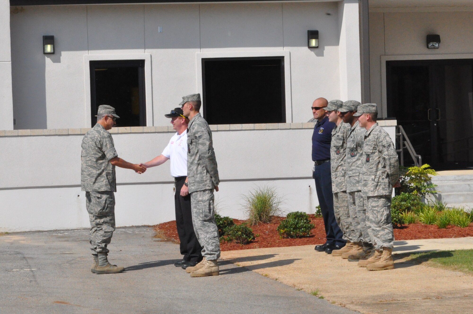 Col. Roger Watkins, 14th FTW commander, is greeted by Senior Airman Nathan Milan, 14th CES Fire Emergency Services Flight, at an open house at the newly renovated auxiliary air field in Shuqulak, Miss. (U.S. Air Force photo/Sonic Johnson).