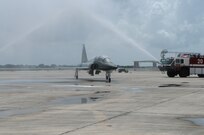 Maj. Gen. Gregory Feest, 19th Air Force commander, guides his T-38 Talon through the water arc provided by the Randolph Fire Department July 23, in honor of his final flight at Randolph Air Force Base. (U.S. Air Force photo/Rich McFadden)