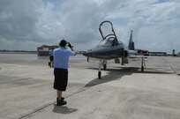 Frank Womack (left), 12th Flying Training Wing maintenance division, guides Maj. Gen. Gregory Feest, 19th Air Force commander, and his T-38 Talon aircraft to its parking spot. Gen. Feest just completed his final flight at Randolph Air Force Base July 23.(U.S. Air Force photo/Rich McFadden)
