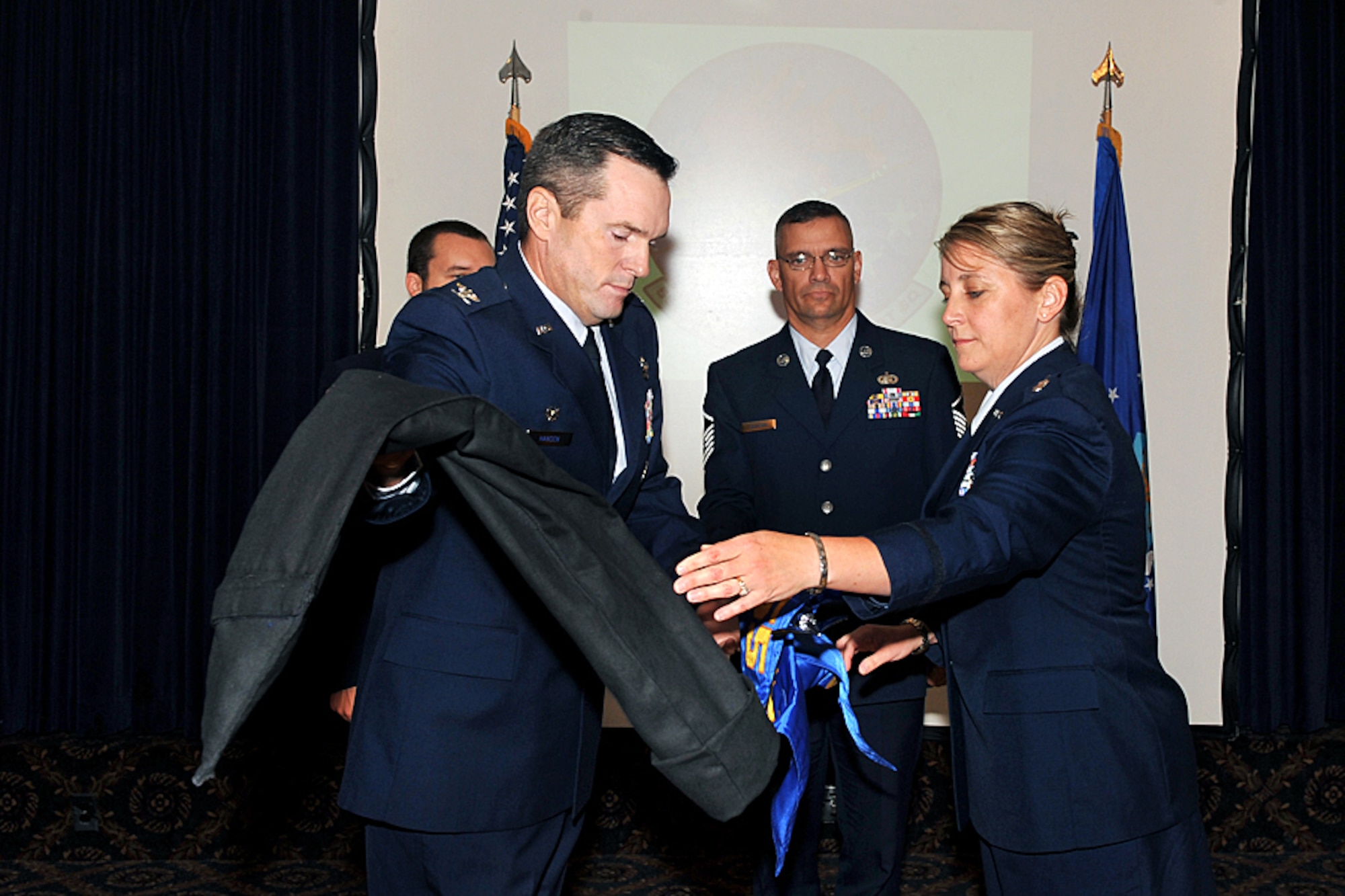 OFFUTT AIR FORCE BASE, Neb. - Col. John Hansen, 55th Operations Group commander, and Lt. Col. Jenifer Warren, 55th Intelligence Support Squadron incoming commander, unveil the squadron flag during the 55th ISS Activation and Assumption of Command ceremony at the Patriot Club July 22. U.S. Air Force photo by Charles Haymond