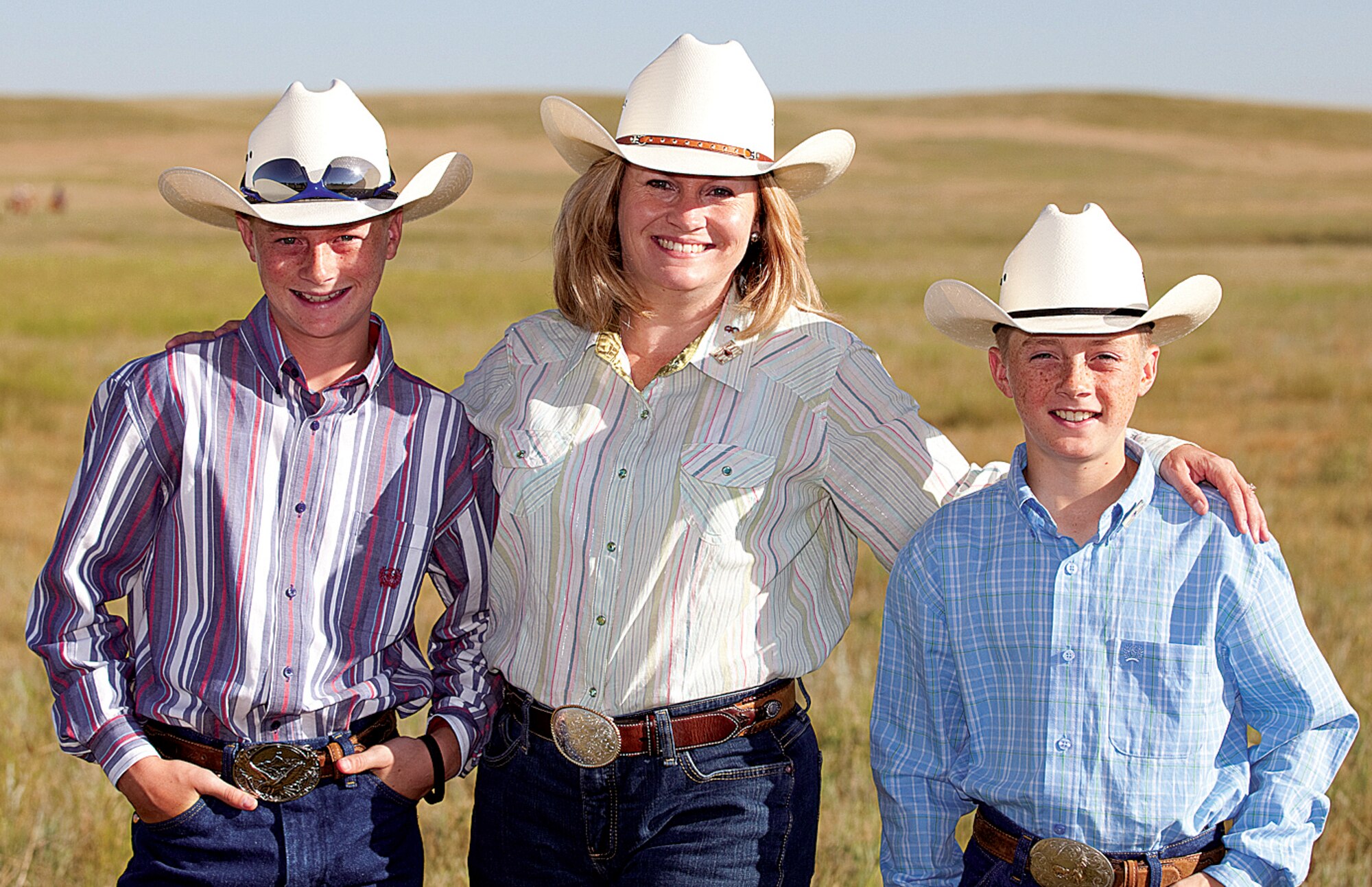 Julie Tims, wife of Col. Greg Tims, 90th Missile Wing commander, and their sons, Kevin and Brian, pose for a photo during the CFD cattle drive July 19. (U.S. Air Force photo by Jeff Allred)